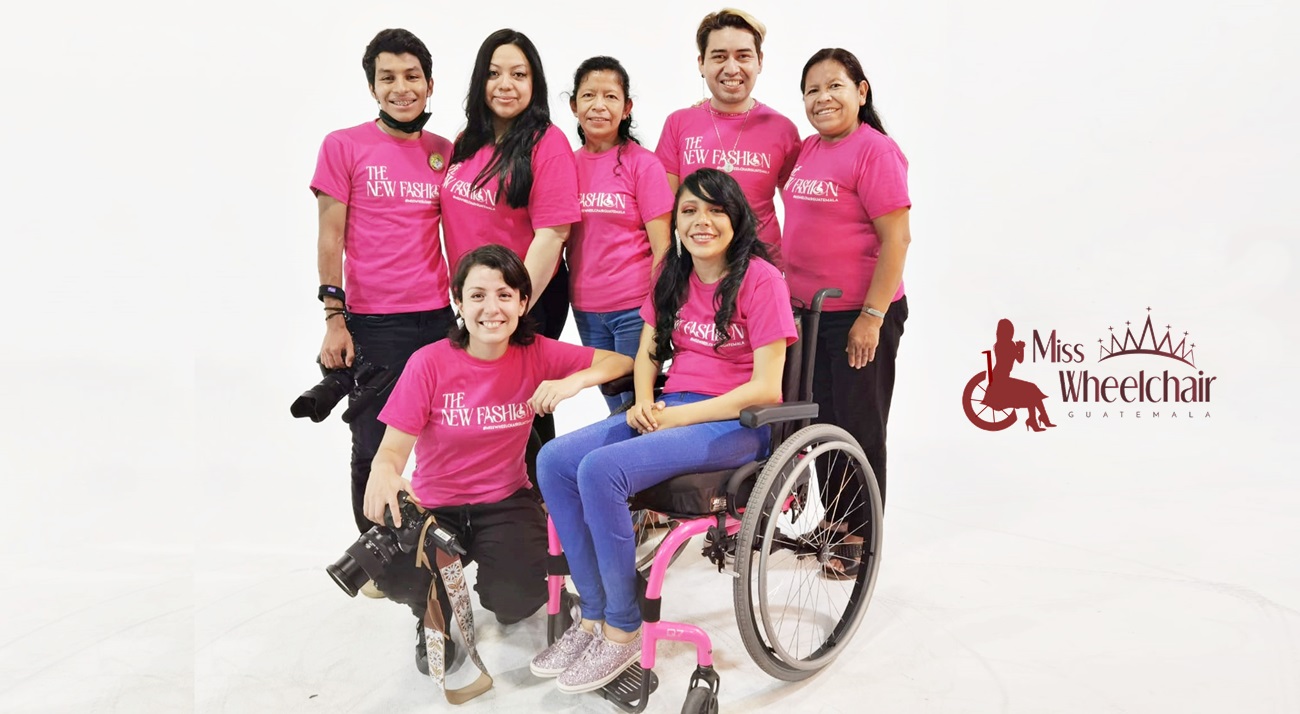 En la locación de la sesión fotográfica, con camisetas color rosa alusivas a la ocasión, la directora del certamen en su silla de ruedas rodeada de varios de sus colaboradores
