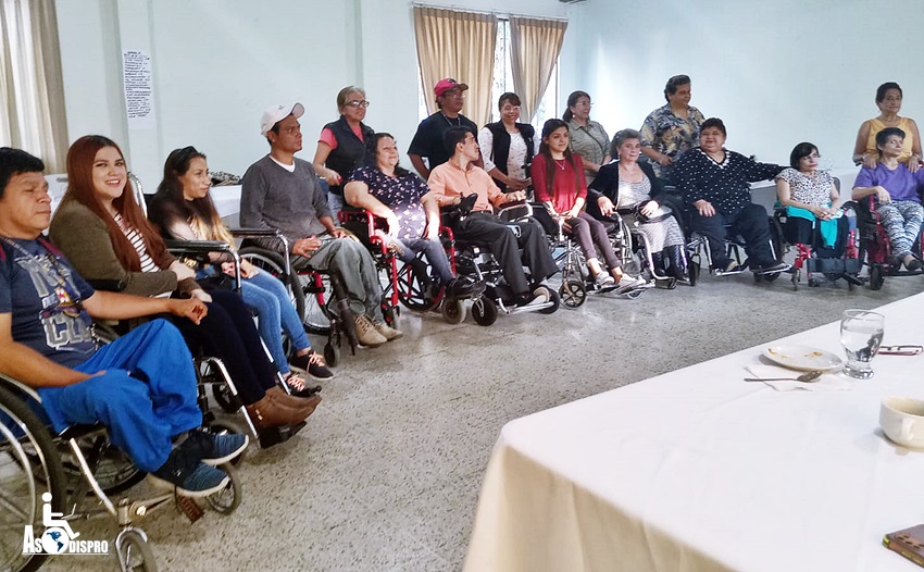 Es una foto grupal, 11 personas en silla de ruedas, y 6 personas de pie tras de ellas.