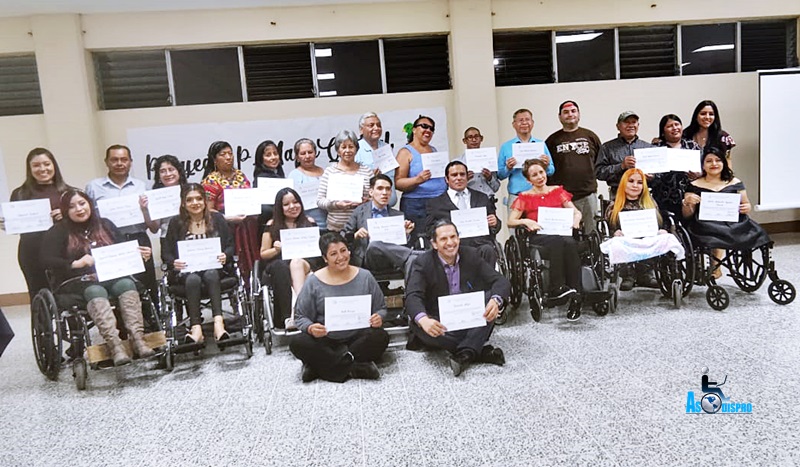 27 personas participantes de la capacitación, muestran sus diplomas.