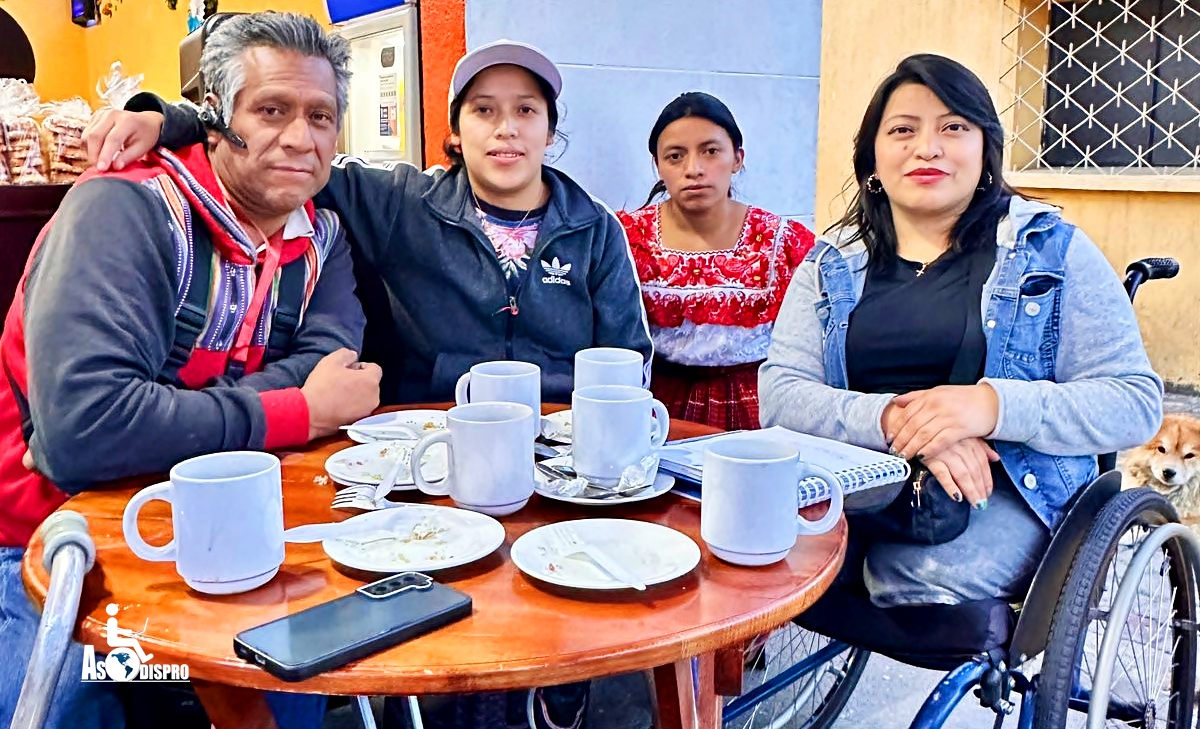 Primeros afiliadops a Asodispro Totonicapán En una mesa, posan 4 de los miembros de la Filial Asodispro en Totonicapán