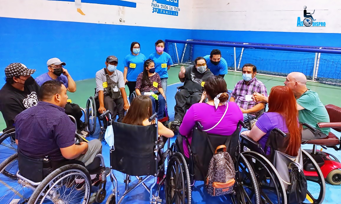 En una cancha deportiva, se reúnen varios miembros de Asodispro y voluntarios.