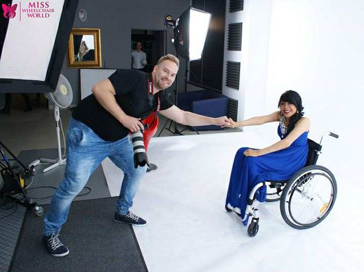 El fotógrafo del concurso saluda de mano a Stephane Pahola Solano quien viste un traje de noche azul 