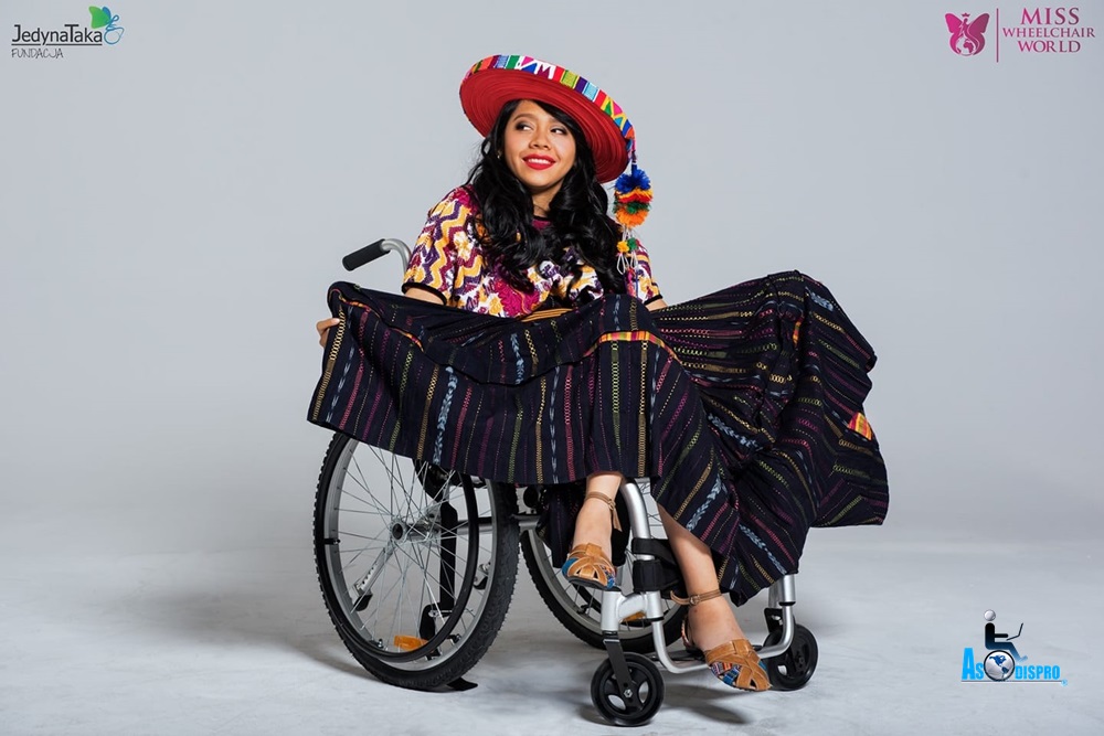 Pahola sonríe tomando las puntas de su vestido regional que utilizó en el concurso internacional 