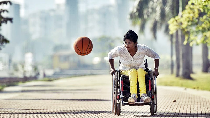 Nisha persigue un balón de básquetbol en un parqué. 