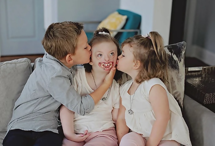 Sentados a su lado, Sophia en medio, su hermano y hermana de casi la misma edad, la besan en los pómulos. 