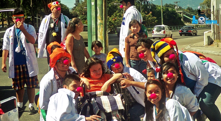 Gaby, una niña en silla de ruedas, posa junto a varios voluntarios de Fábrica de Sonrisas