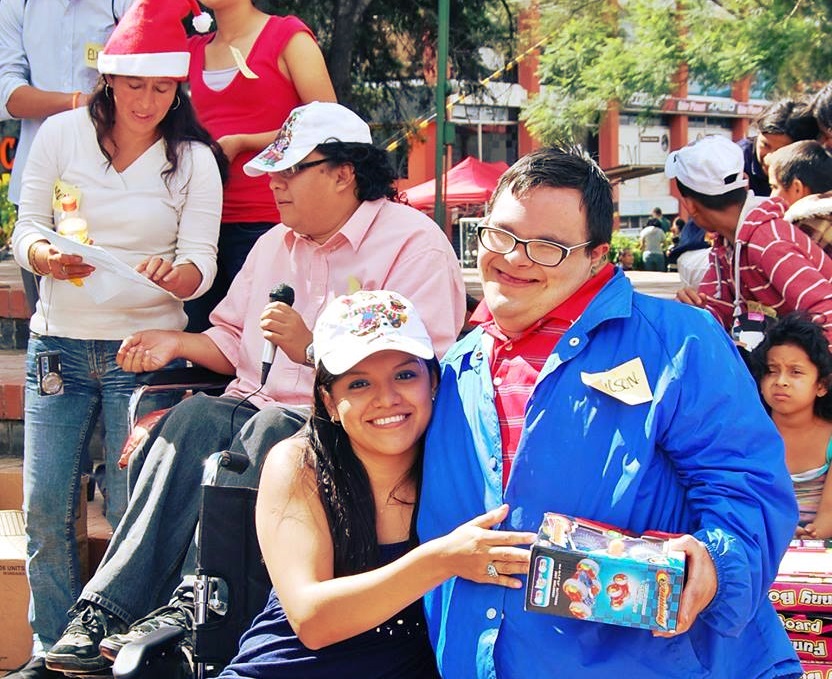 Yojana Chávez de Asodispro entrega un regalo a Wilson, un joven con síndrome de Down 