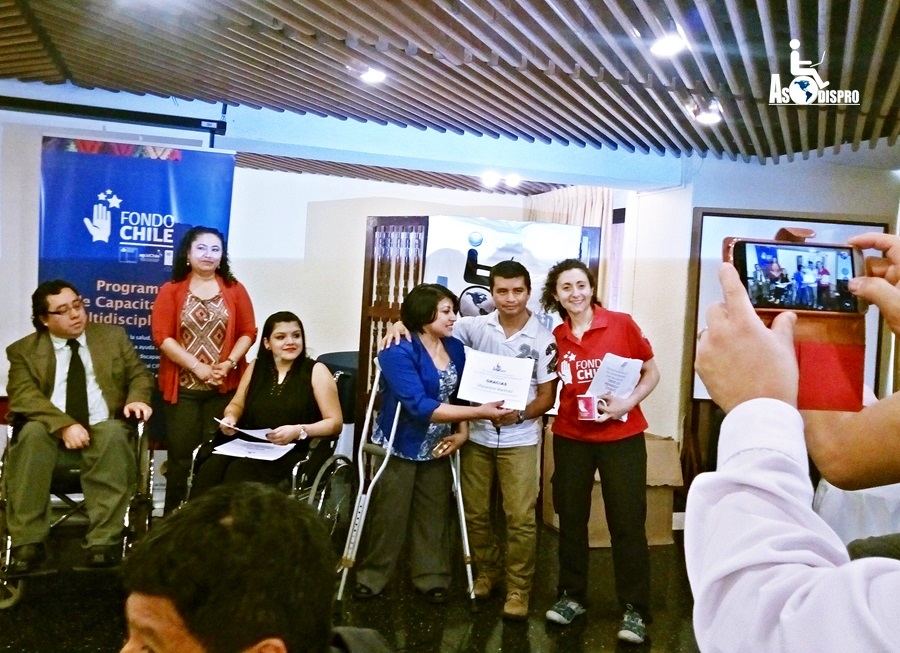 Durante la entrega de diplomas, personas con discapacidad de ASODISPRO entregan reconocimientos a los capacitadores chilenos