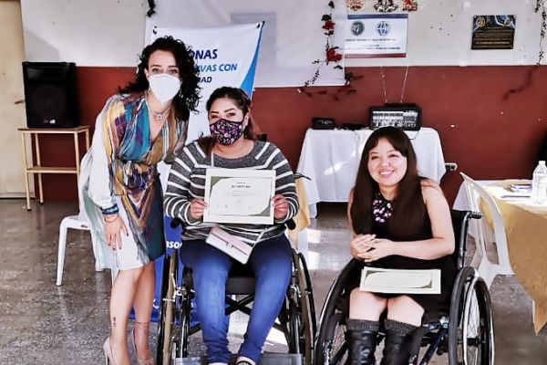 Eimy entrega su diploma de participación a Ingrid, posan para la fotografía junto a Jessica