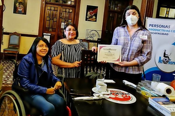 En la mesa que presidio el evento, las tres chicas posan con el diploma. 