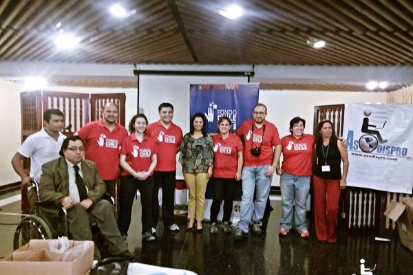 Después de un evento, 11 delegados posan en el escenario de un hotel.